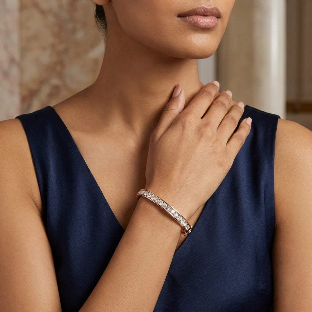 A close-up lifestyle shot of a model wearing a slim diamond band bracelet on her wrist, paired with a navy blue satin dress.