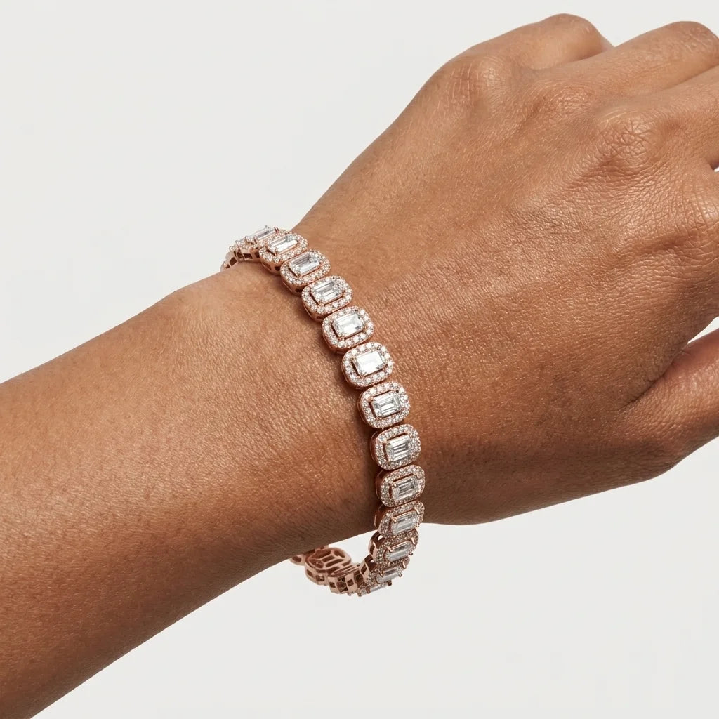 A rose gold tennis bracelet with radiant-cut clear diamonds, shown worn on a person's wrist against a light gray background.