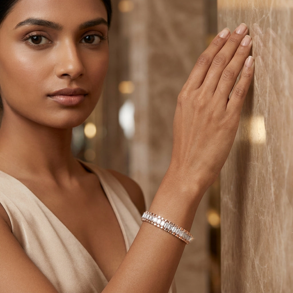 A woman wearing a sparkling diamond tennis bracelet, shown in a close-up lifestyle shot against a warm marble wall.