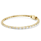 A gold tennis bracelet with baguette-cut clear diamonds, displayed in a circular shape on a clean white background.