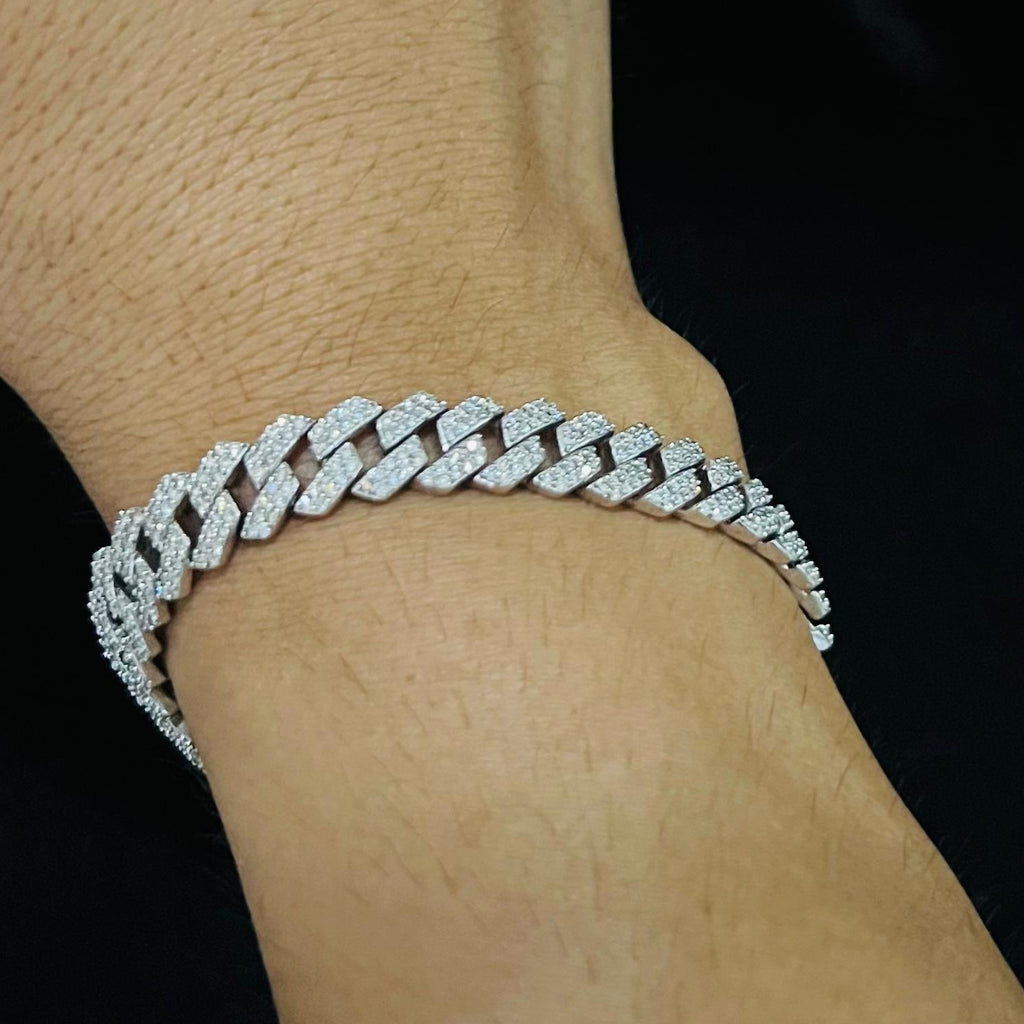 Gold bracelet with diamond accents on a wrist against a black background