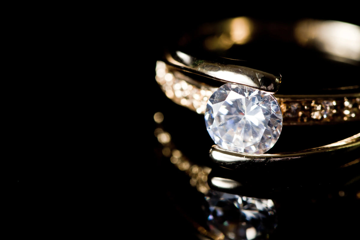 Gold ring with a diamond on a black background