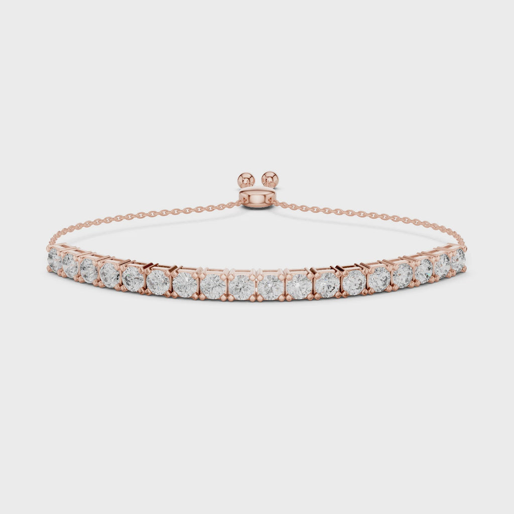 Rose gold bracelet with diamond accents on a white surface, is rotating parallel to the surface to show its view from all the sides.