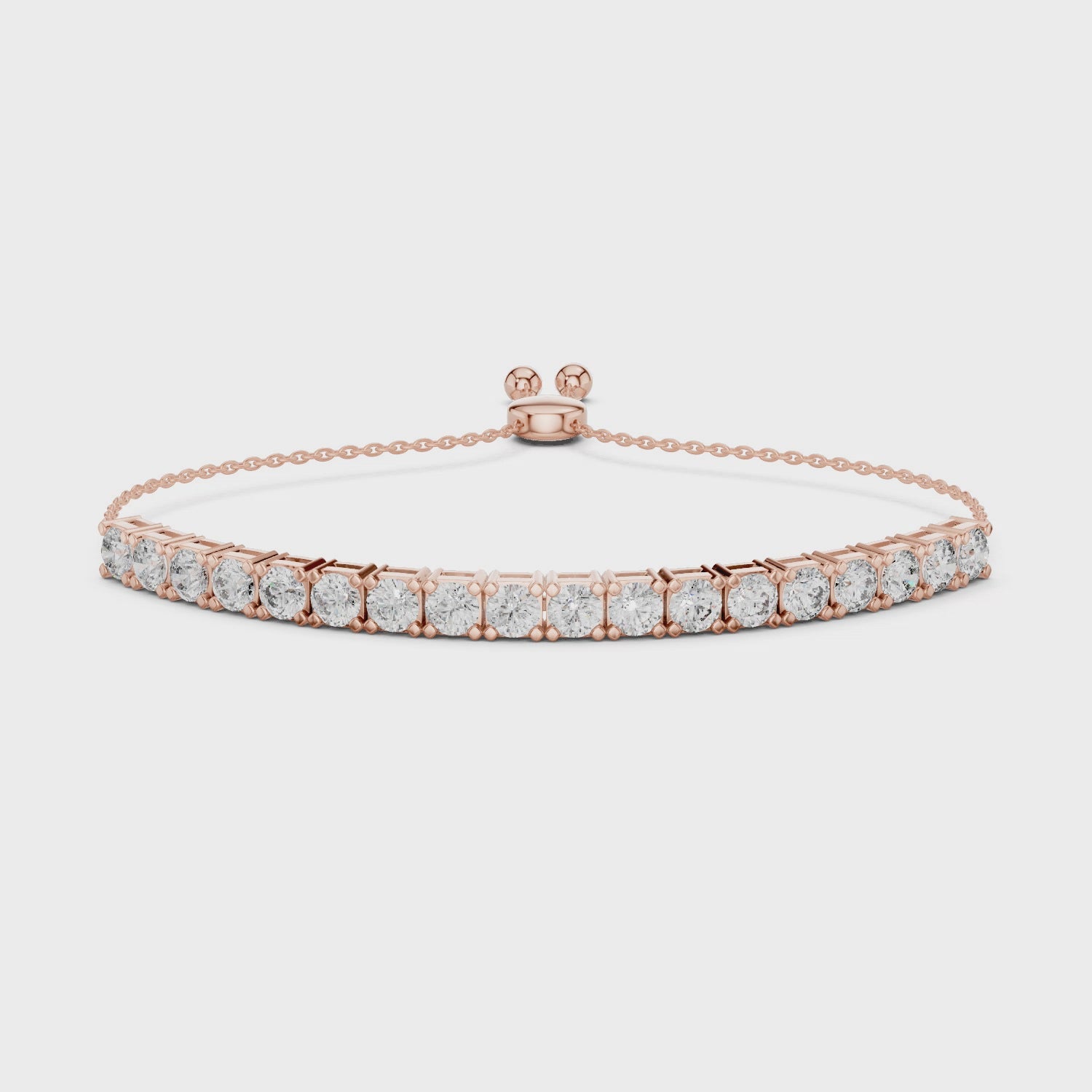 Rose gold bracelet with diamond accents on a white surface, is rotating parallel to the surface to show its view from all the sides.