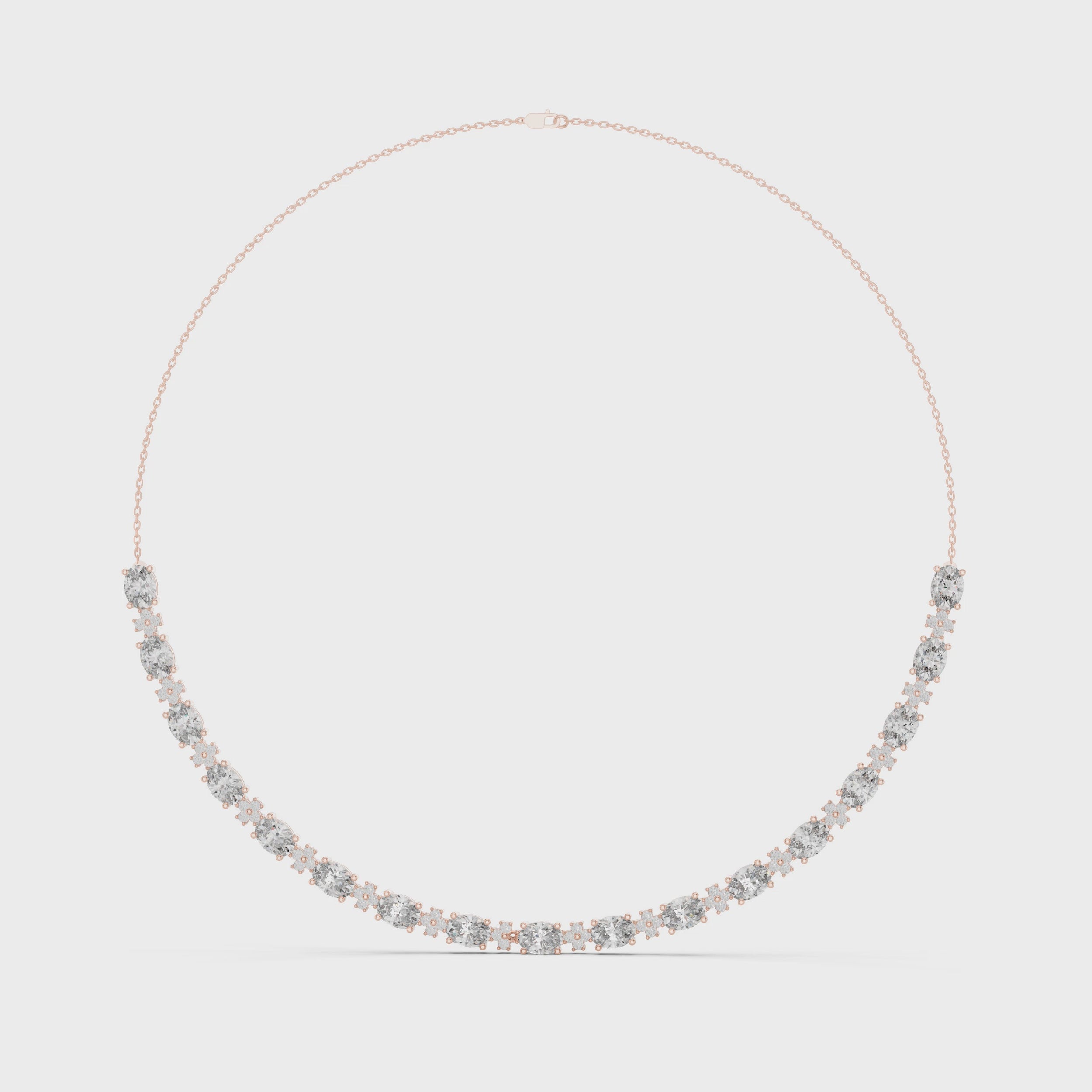 Oval and round shape diamond necklace in solid gold is rotating horizontally against a white surface.