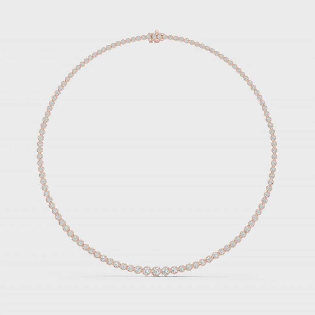 Tennis necklace with bezel-set natural diamonds is rotating horizontal on a white surface.