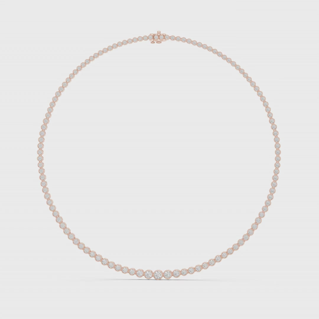 Tennis necklace with bezel-set natural diamonds is rotating horizontal on a white surface.