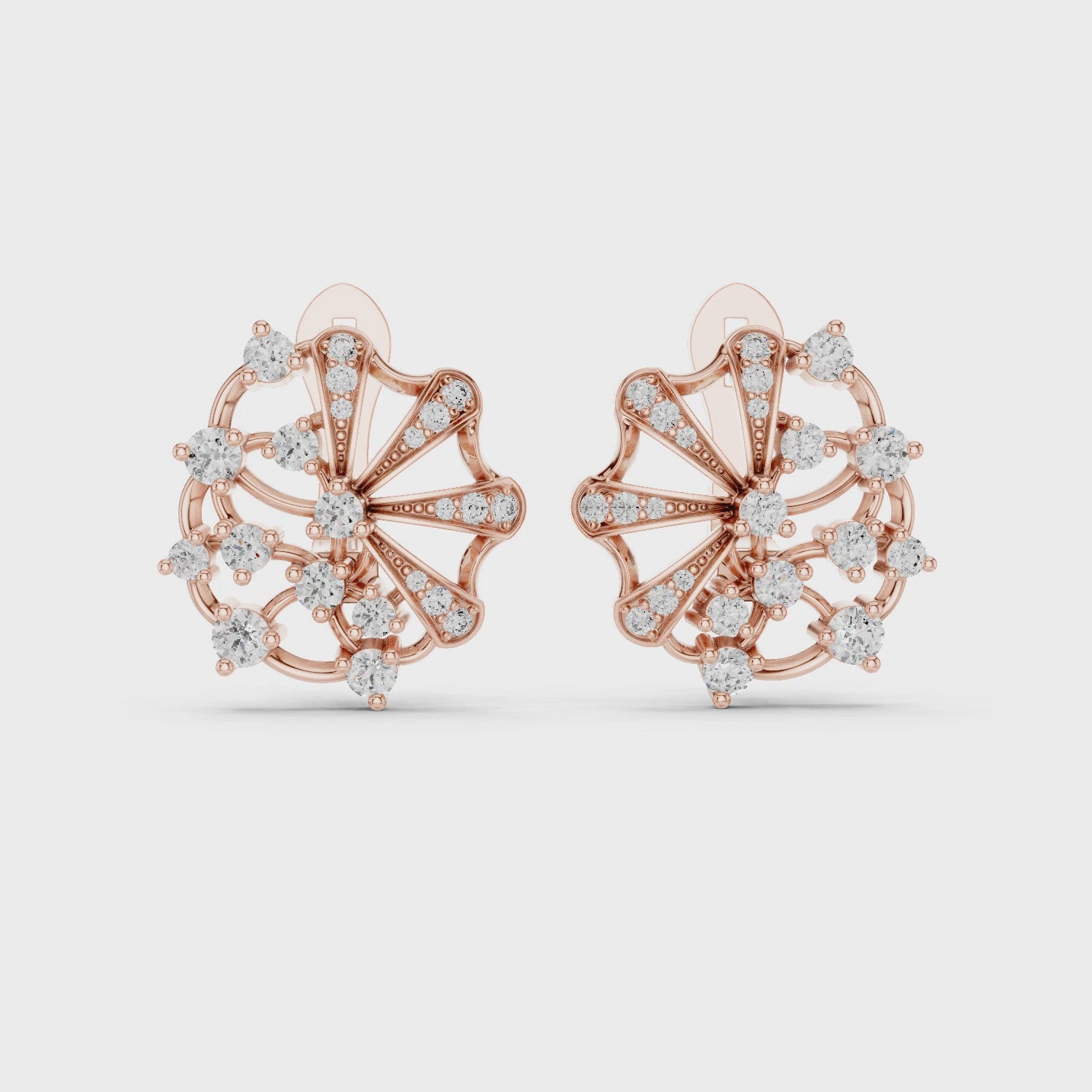 Rose gold stud earrings with diamond accents, are rotating horizontally to the white surface on a clean white background.