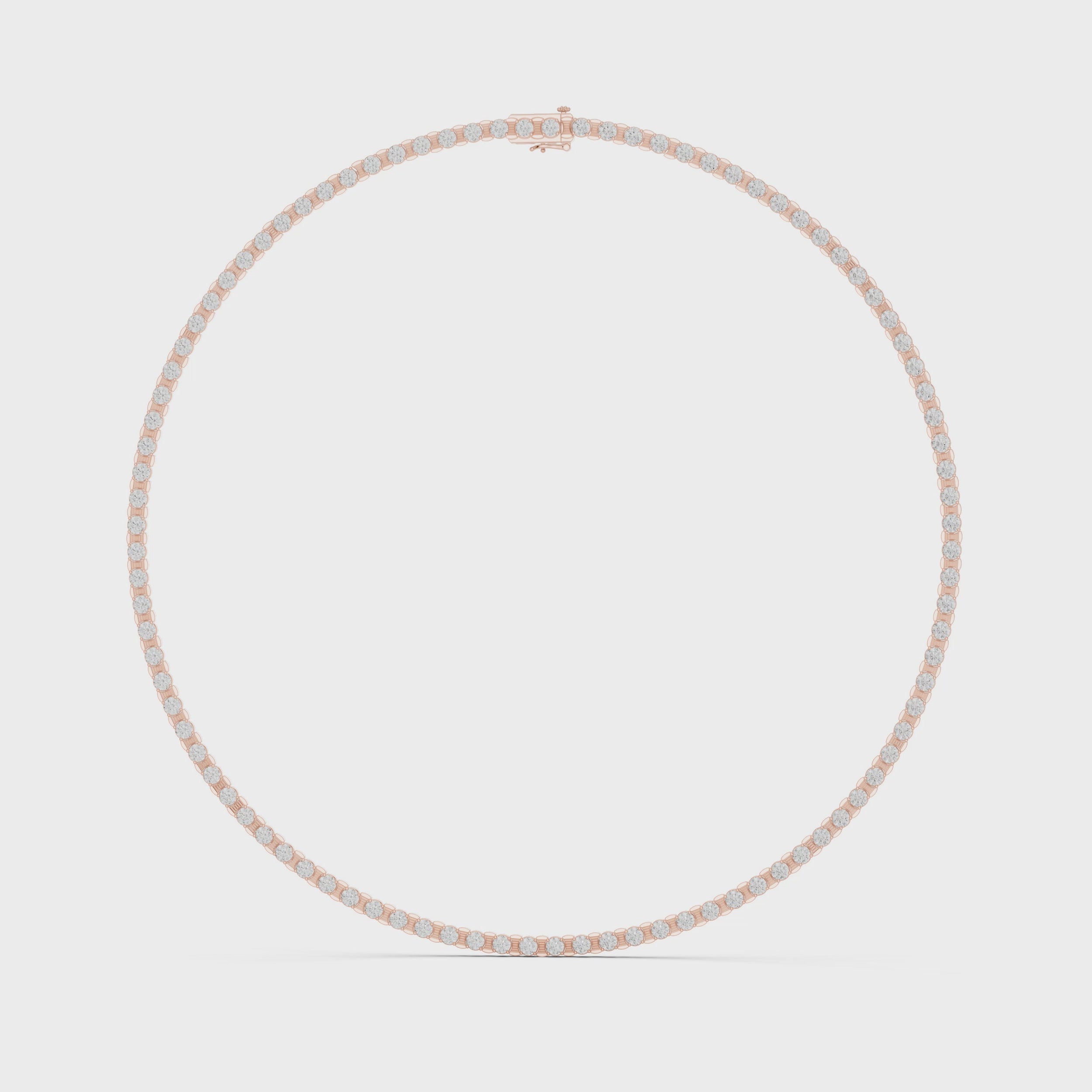 Rose gold and diamond tennis necklace is rotating horizontally against a white surface.