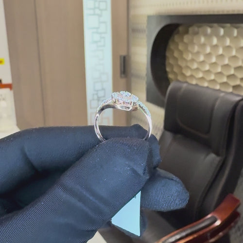 Rose gold ring with diamond accents is holding by a hand which is worn black gloves and showing the ring from every angle by tilting the hand and bringing closer hand to show the ring clearly against the neutral background.