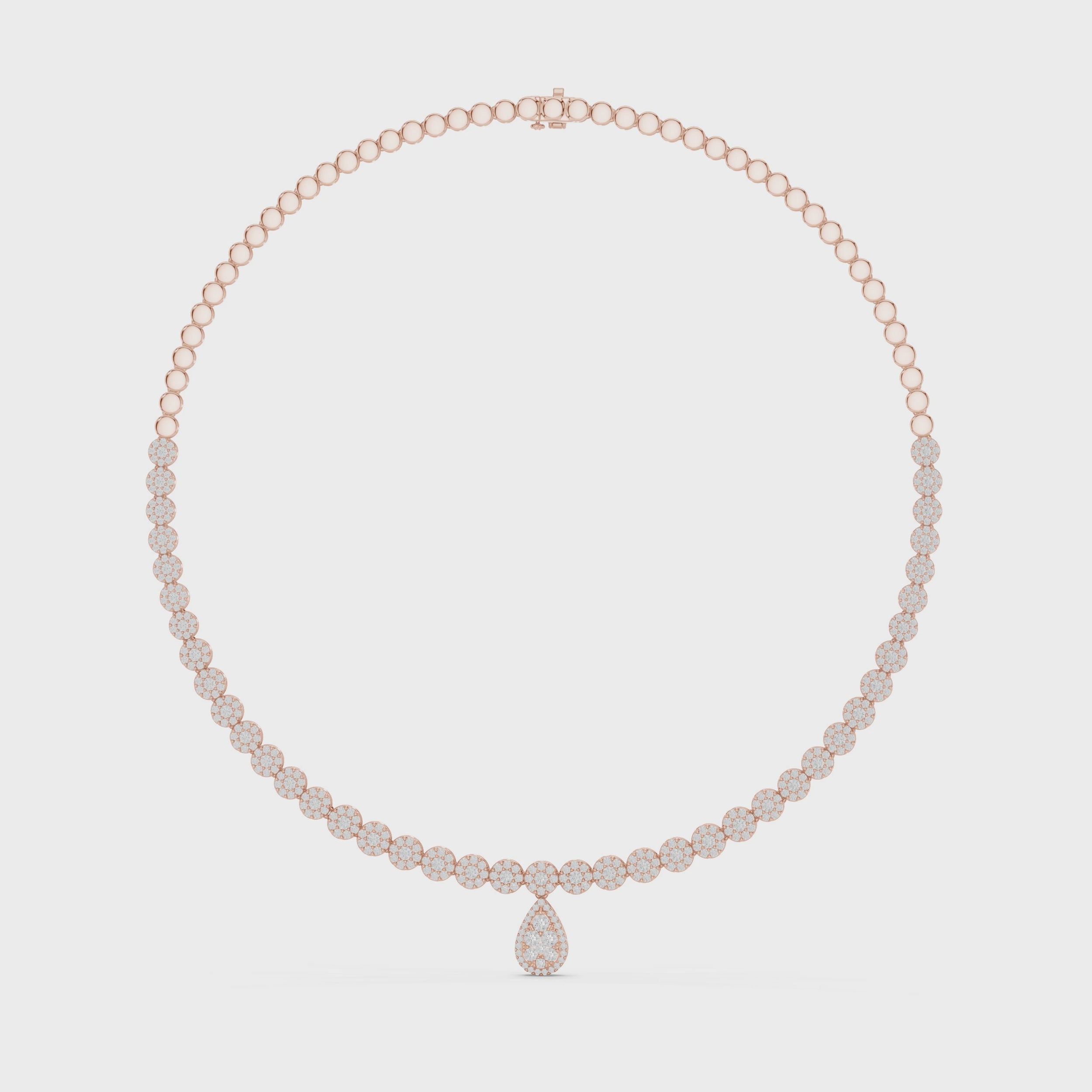 Diamond cluster tennis necklace with a pear diamond cluster drop is rotating horizontal against the white surface.
