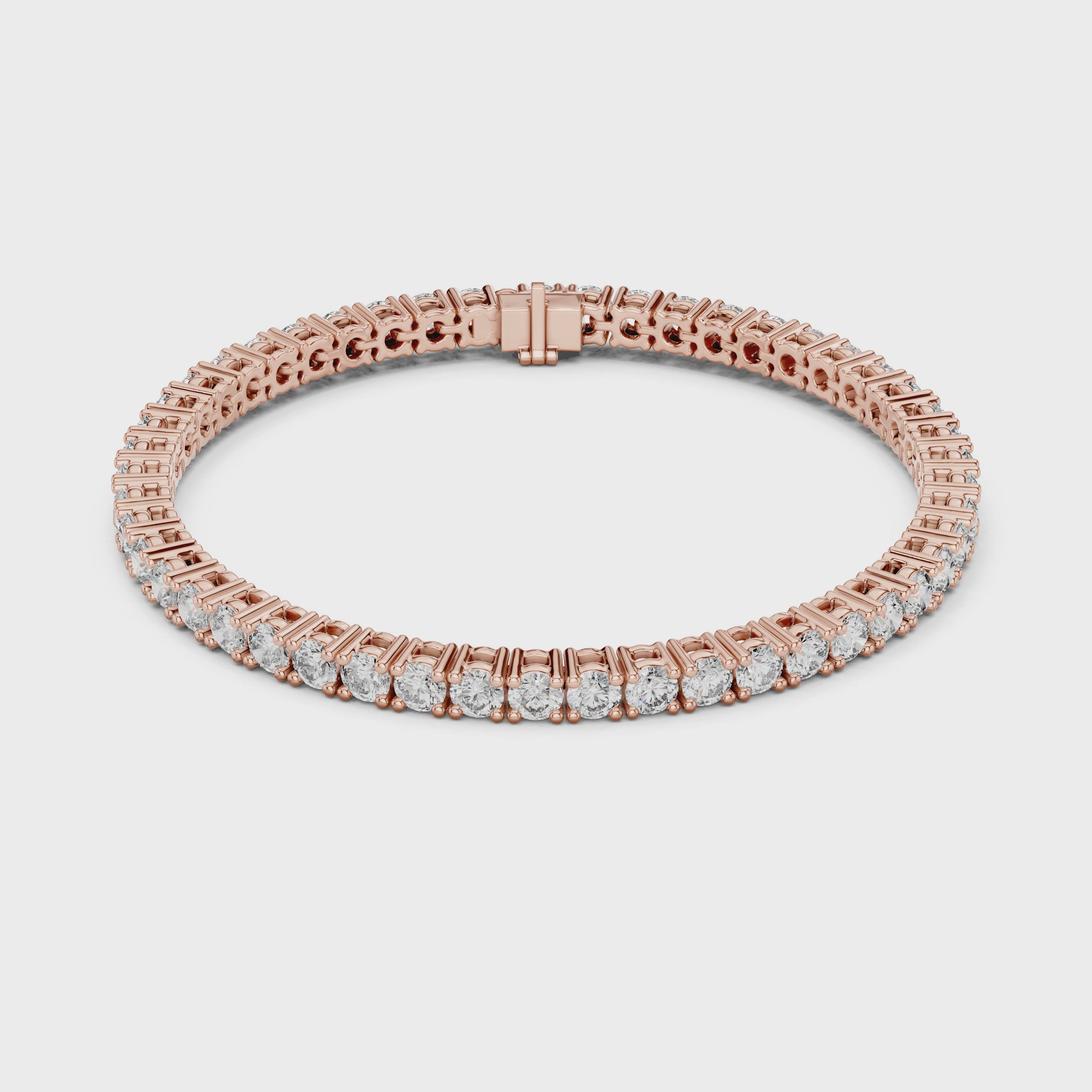 A rose gold tennis bracelet with a continuous row of round-cut clear diamonds, displayed on a clean white surface and rotating parallel to the surface.