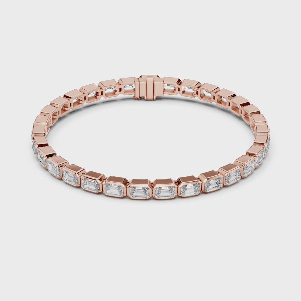 A rose gold tennis bracelet featuring rectangular emerald-shape clear diamonds in a continuous link design, shown on a plain white background and rotating parallel to the surface to show its view from every side.