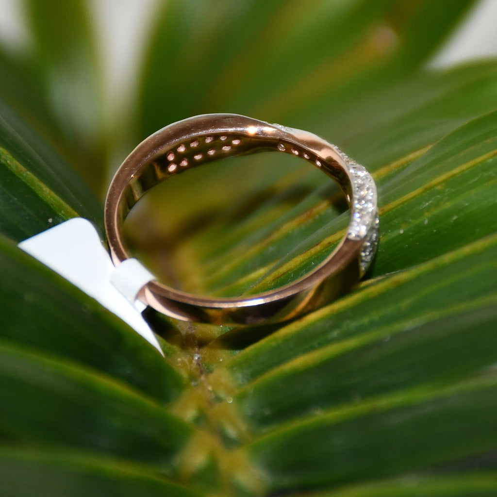 Gold ring with diamonds on a green leaf