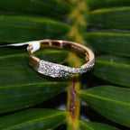 Gold ring with diamonds on a green leaf background