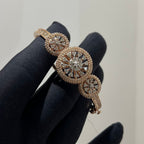 Rose gold bracelet with diamond accents on a black glove against a neutral background