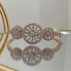 Rose gold bracelet with diamond accents on a reflective surface