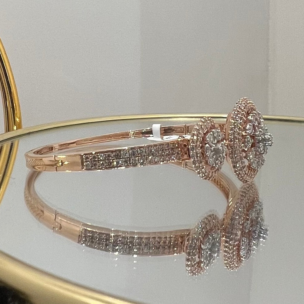 Rose gold bracelet with diamond accents on a reflective surface