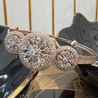 Rose gold bracelet with diamond accents on a reflective surface