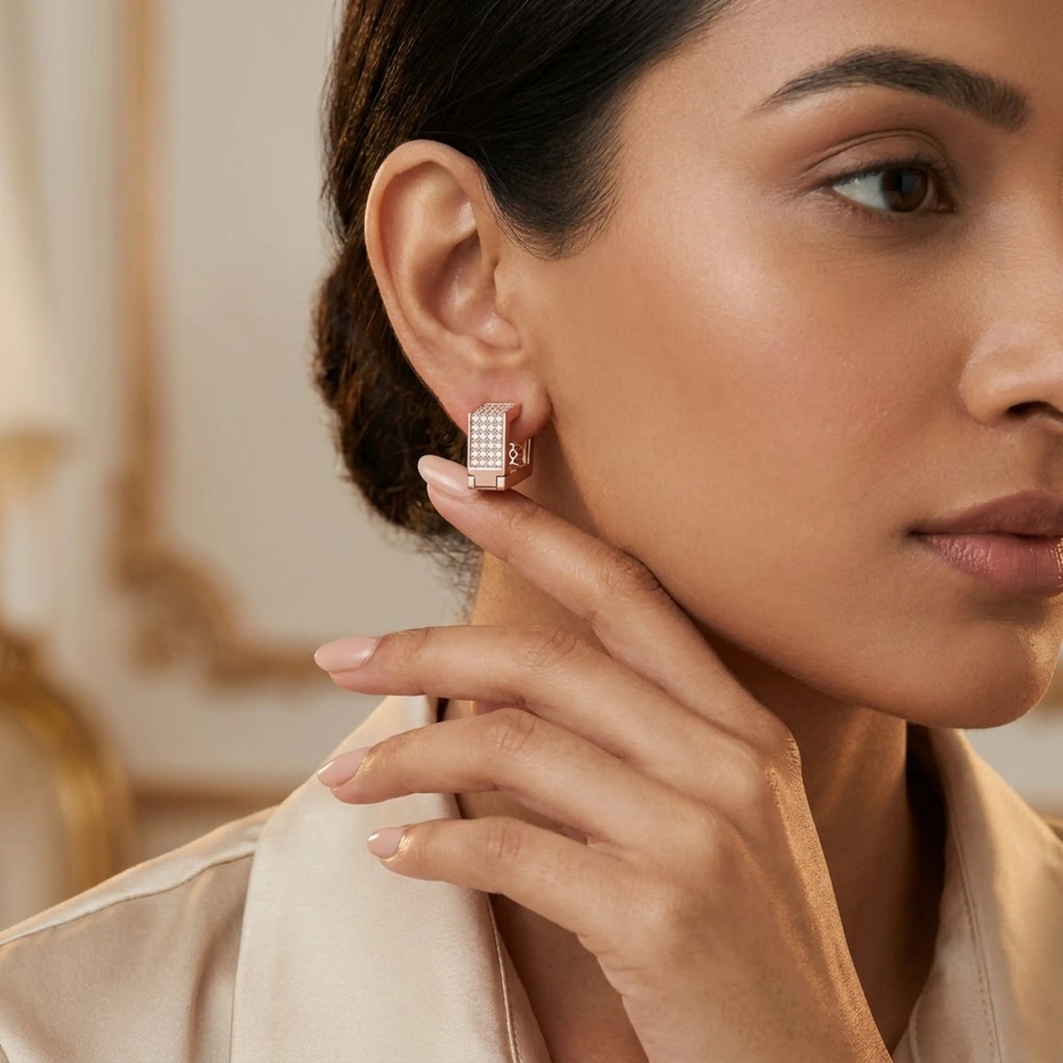 Rose gold earrings with diamond accents is worn by a model against a neutral background.