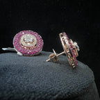 Pair of diamond earrings with pink gemstones on a black background