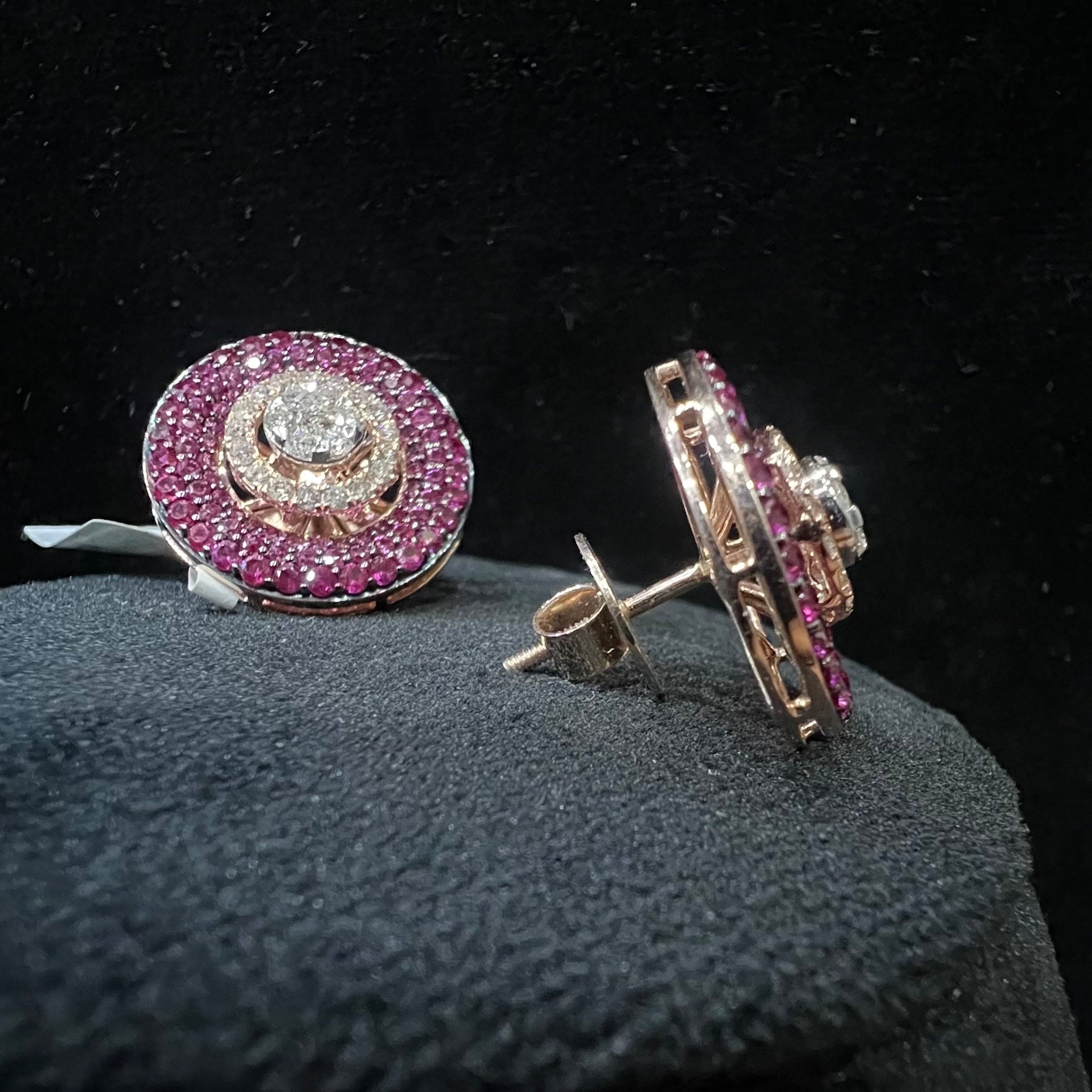 Pair of diamond earrings with pink gemstones on a black background