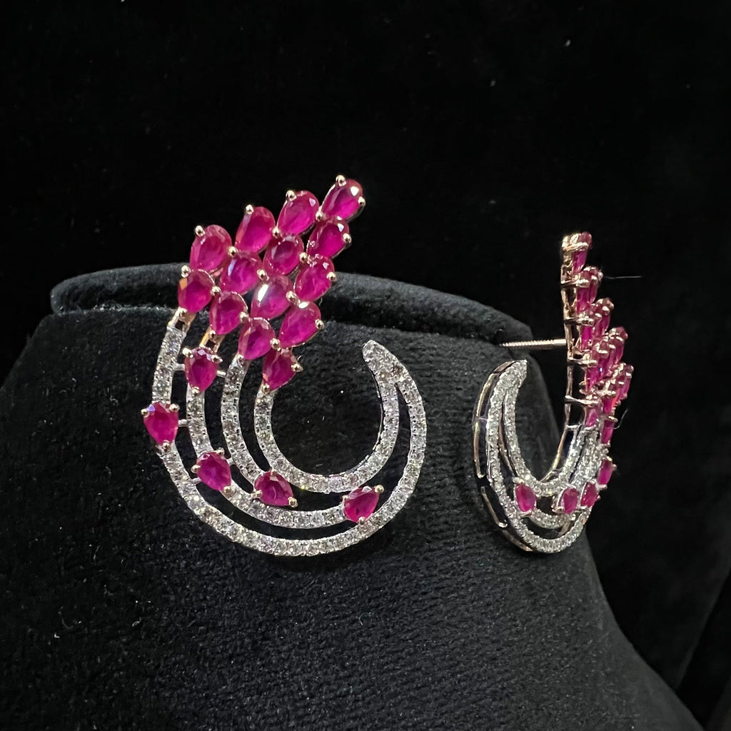 Pair of earrings with pink gemstones and diamonds on a black background