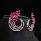 Pair of earrings with pink gemstones and diamonds on a black background