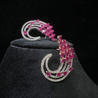 diamond stud earrings with pink gemstones on a black velvet stand.