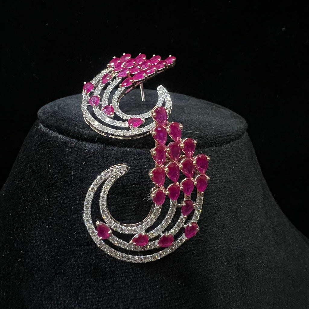 diamond earrings with pink gemstones on a black stand