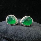 Pair of green gemstone and diamonds earrings on a black background