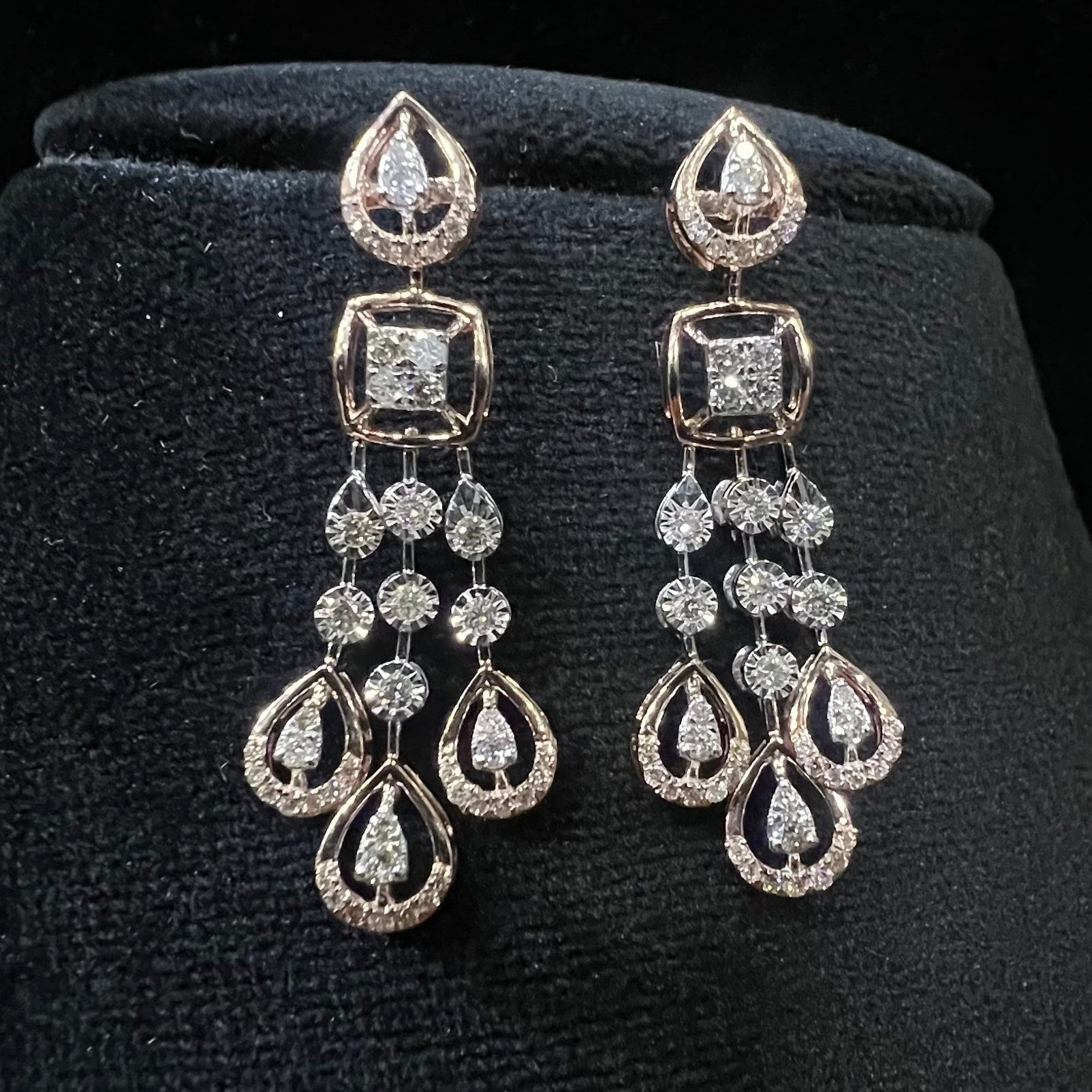 Pair of diamond earrings on a black velvet stand