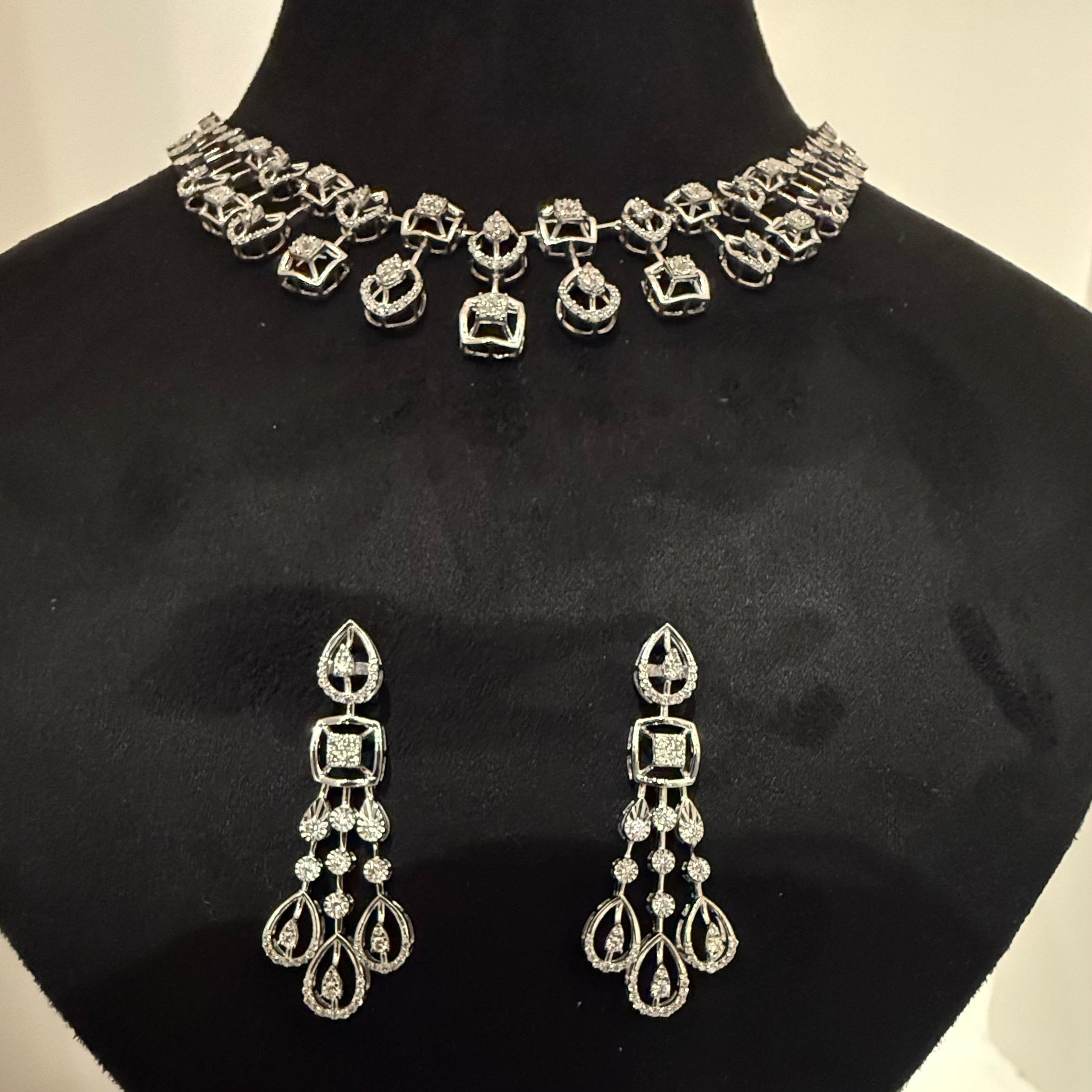 Jewelry set with necklace and earrings on a black mannequin bust.