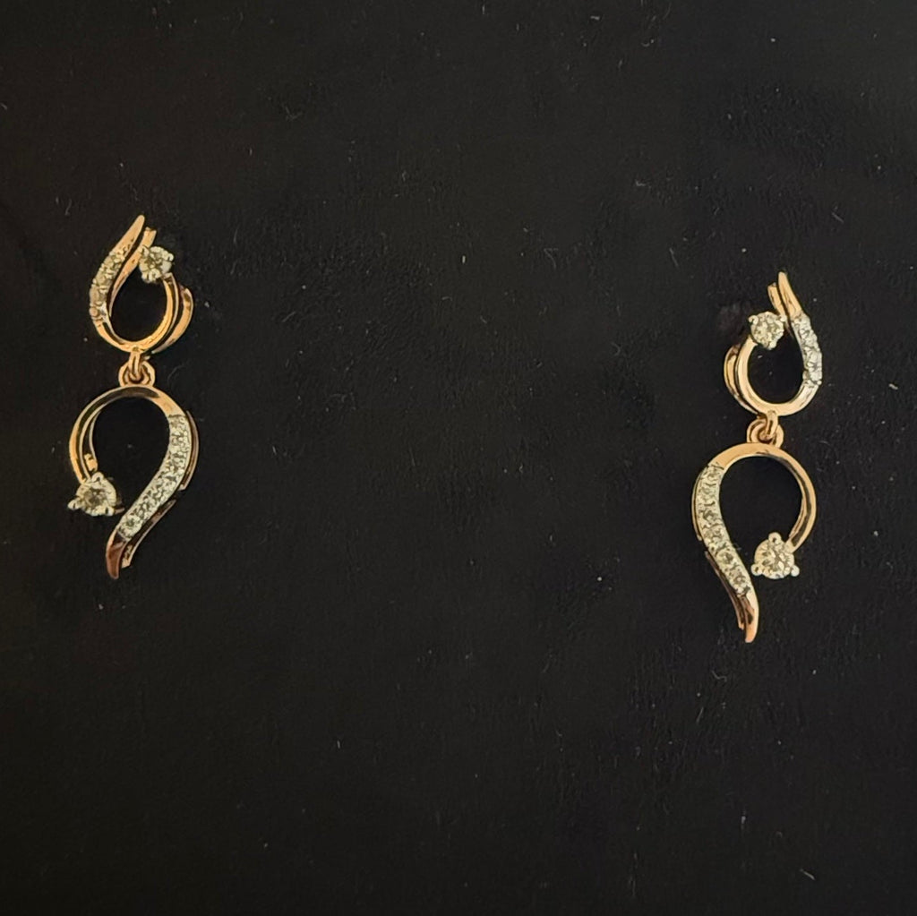 Pair of gold earrings with diamonds on a black background