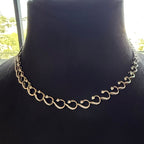Gold diamond necklace on a black mannequin