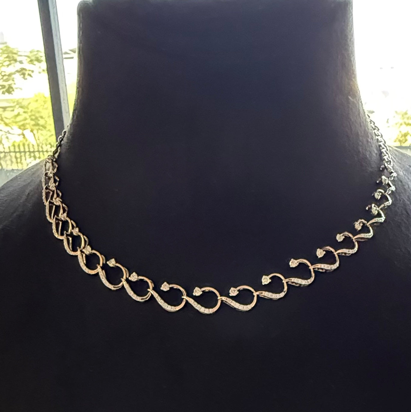 Gold diamond necklace on a black mannequin