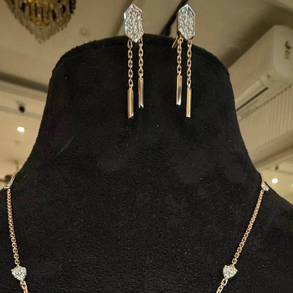 Gold earrings and necklace on a black mannequin bust