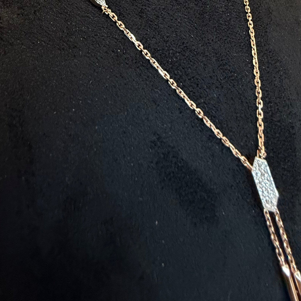Gold necklace with a diamond pendant on a black background
