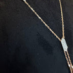 Gold necklace with a diamond pendant on a black background