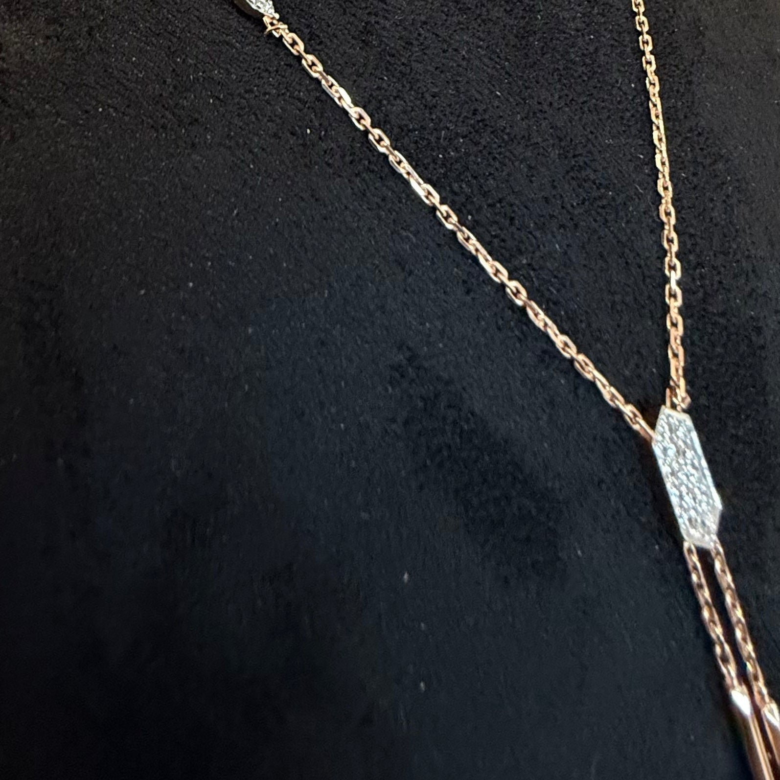 Gold necklace with a diamond pendant on a black background
