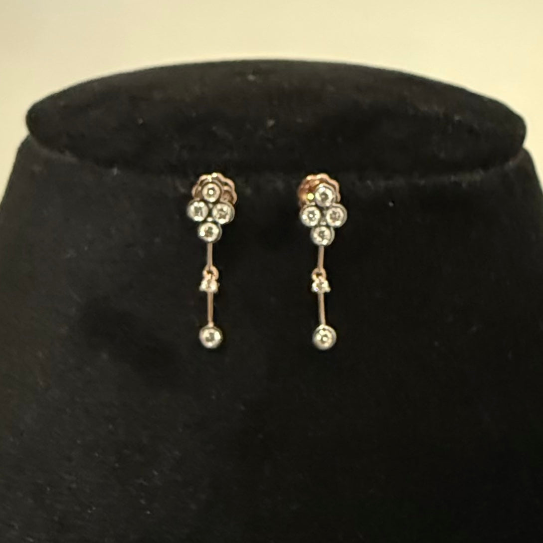 Pair of floral diamond earrings on a black velvet cushion