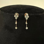 Pair of diamond earrings on a black velvet cushion