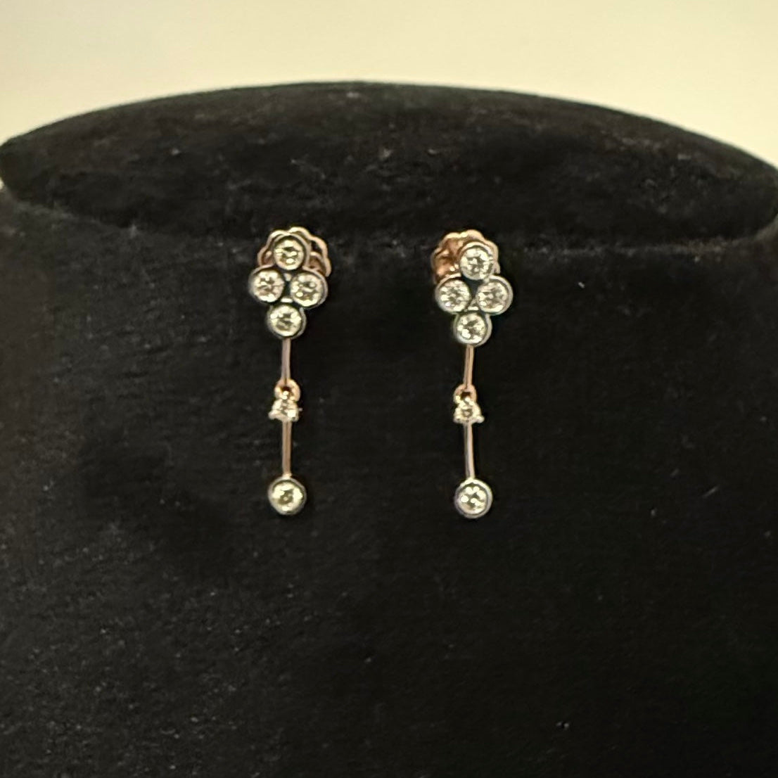 Pair of diamond earrings on a black velvet cushion