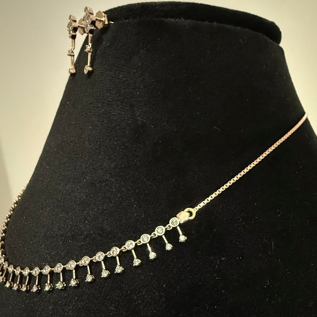 Gold necklace and earrings with diamonds on a black velvet stand