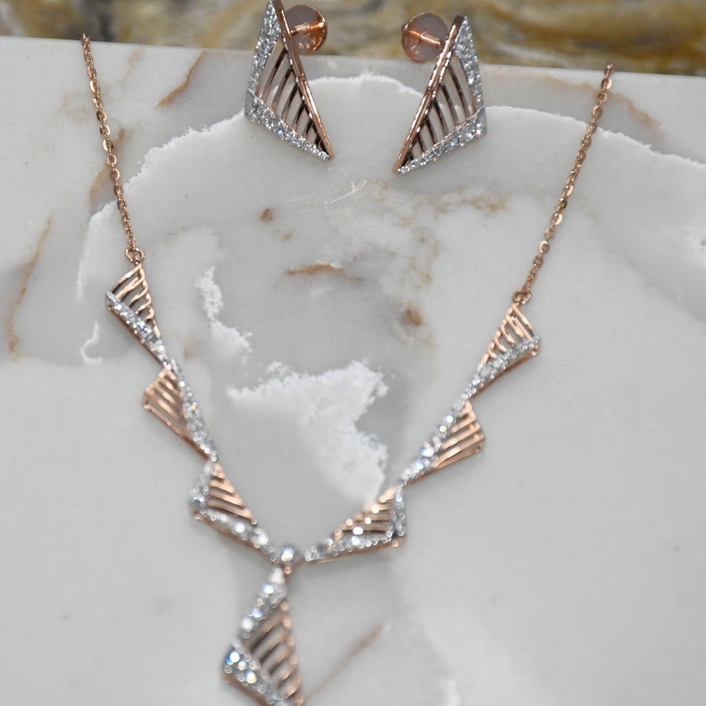Rose gold necklace and earrings on a marble surface
