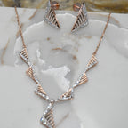 Rose gold necklace and earrings on a marble surface