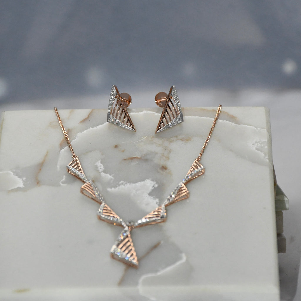 Rose gold necklace and earrings on a marble surface