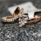 Rose gold ring with a pave set diamonds on a textured surface