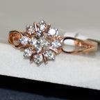 Rose gold ring with diamond accents on a white stone surface