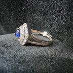 Gold ring with blue gemstone on a textured black surface